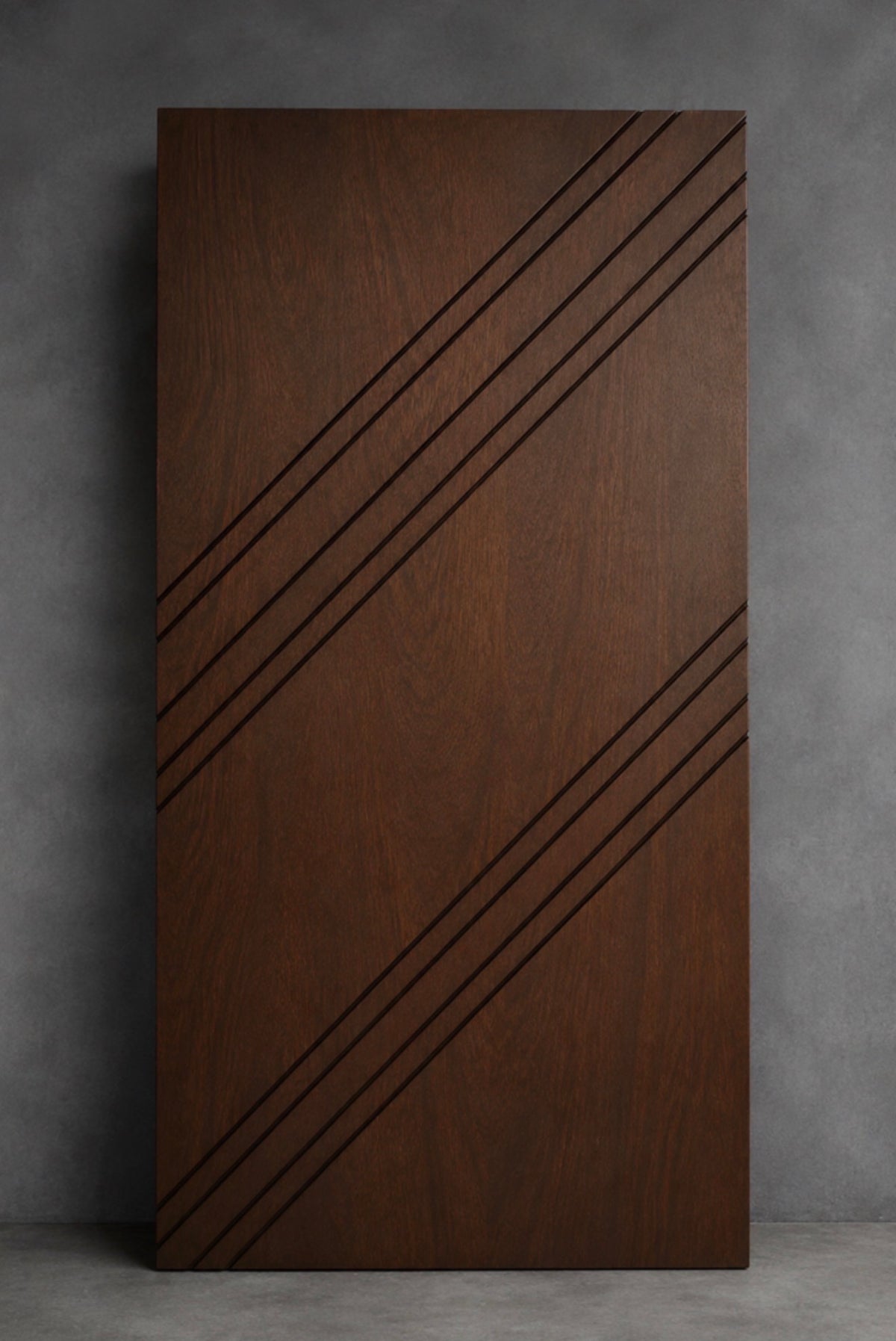 The Amancio custom wood door with rich walnut grain and diagonal architectural detailing by Rustic Luxe Designs.
