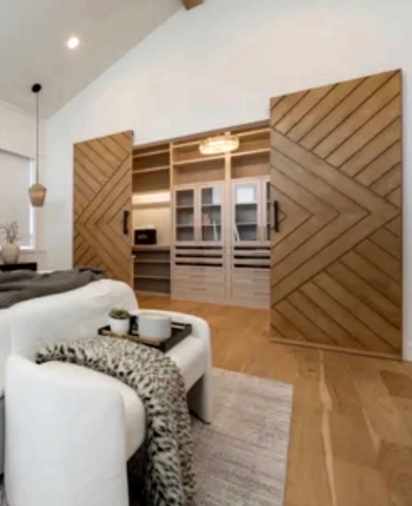White oak chevron sliding doors with concealed invisible track system by Rustic Luxe Designs.