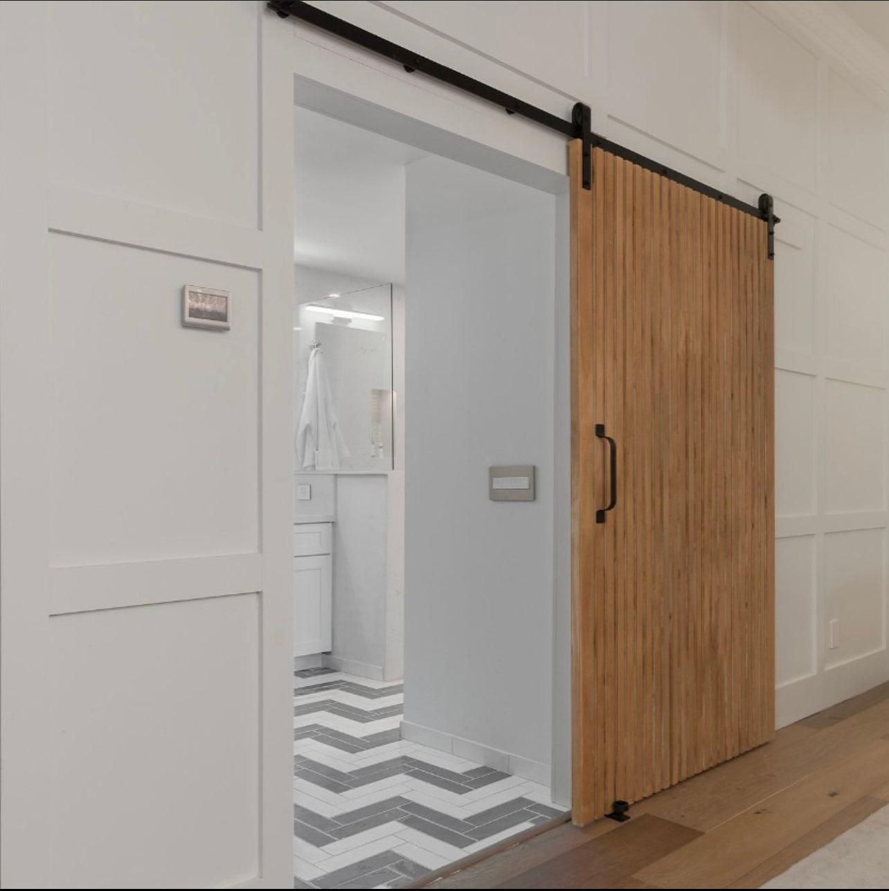Modern wood slat sliding door with solid vertical slat design, custom interior door by Rustic Luxe Designs.