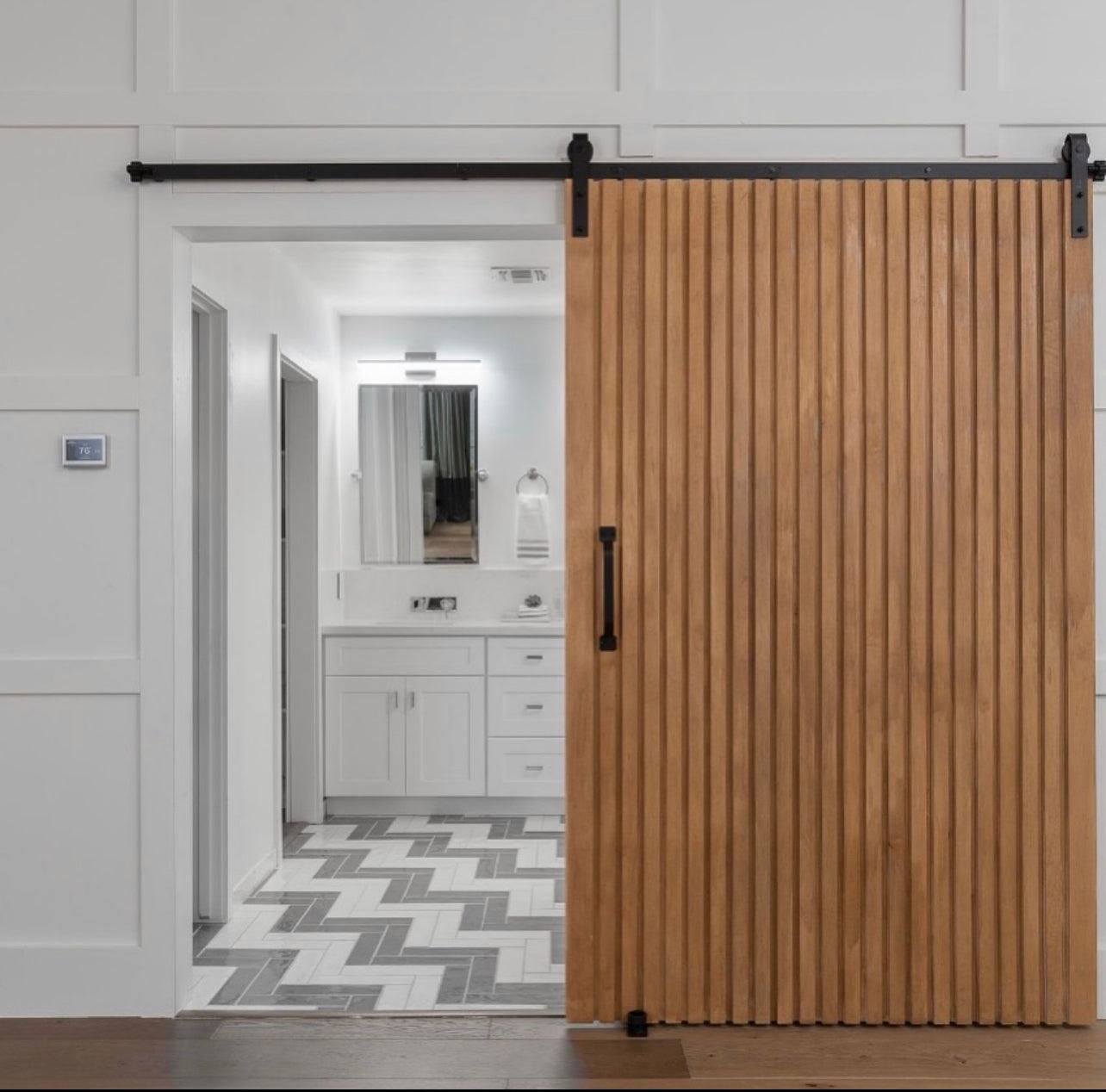 Custom vertical wood slat door with solid panel construction, modern architectural interior door by Rustic Luxe Designs.